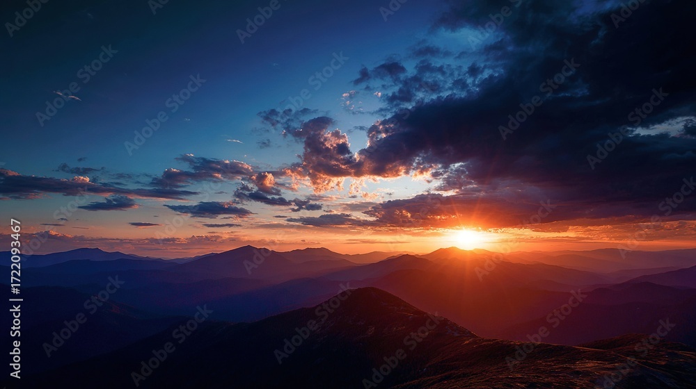 Fototapeta premium The sun sets over the dark blue clouded mountains