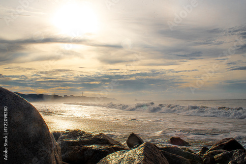 Paisaje. Hermoso amanecer en la playa entre las rocas. Horizontal..