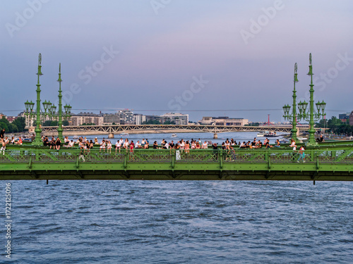 People sitting on the Liberty bridge in Budapest city, Hungary, Europe.