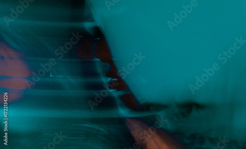 Dreamy moody cinematic portrait of a brunette woman with blue-green glow and long exposure