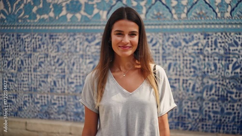Beautiful smiling woman standing before portuguese azulejo tiles