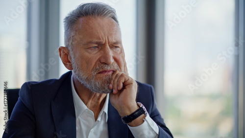 Frowned leader looking decisions financial problems at light workspace closeup. 