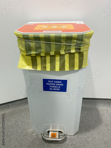 Orange-lidded clinical waste bin with foot pedal—supports hygiene standards and biohazard control.