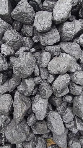 A pile of dark, lumpy coal gleams with a slight sheen, showing a rough, varied texture. Video 4k