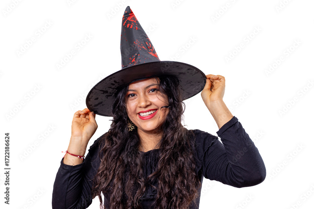 Fototapeta premium Young hispanic woman in a playful witch costume and black pointy hat, smiling and posing for a festive halloween studio portrait on a clean white background