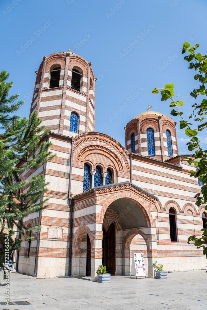 Fototapeta premium Exterior of Saint Nicholas Church with tree leaves in summer. Batumi, Adjara region, Georgia.