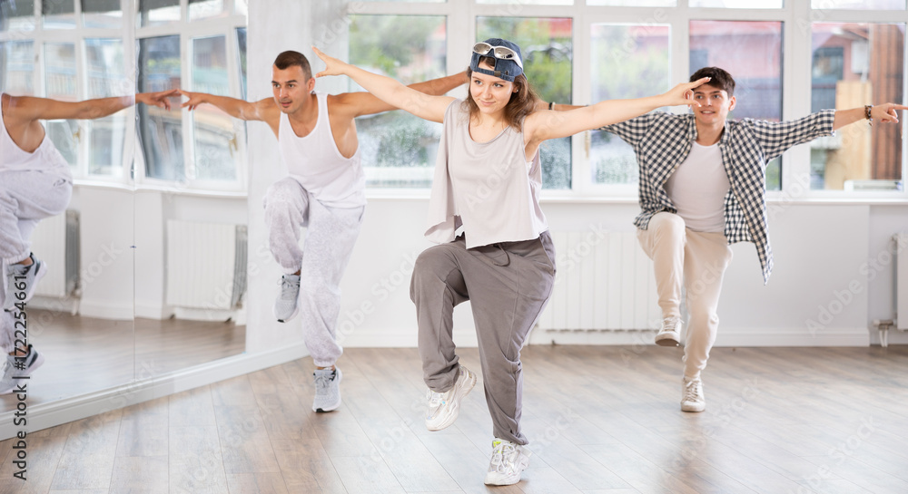 Fototapeta premium Dynamic young woman training hip hop reject step move in dancehall during workout session