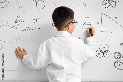 Cute little boy writing on ...