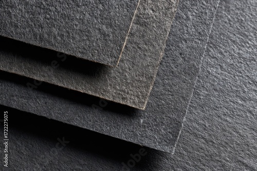 Dark gray rectangular slabs layered,  showing texture