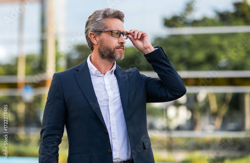 Successful businessman in suit, banner. Leadership and success. Business success. Professional entrepreneur expressing success. Mature Hispanic businessman. Business man outdoor portrait