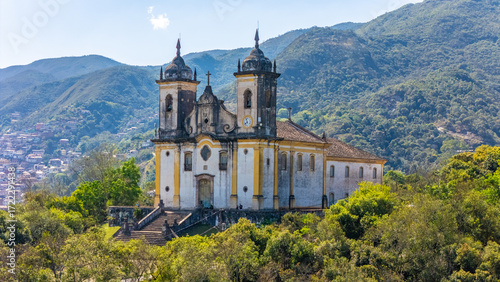 Schilderij op canvas Vista aérea em perspectiva da Igreja de São Francisco de Paula com as montanhas ao fundo, no centro histórico de Ouro Preto, Minas Gerais, Brasil