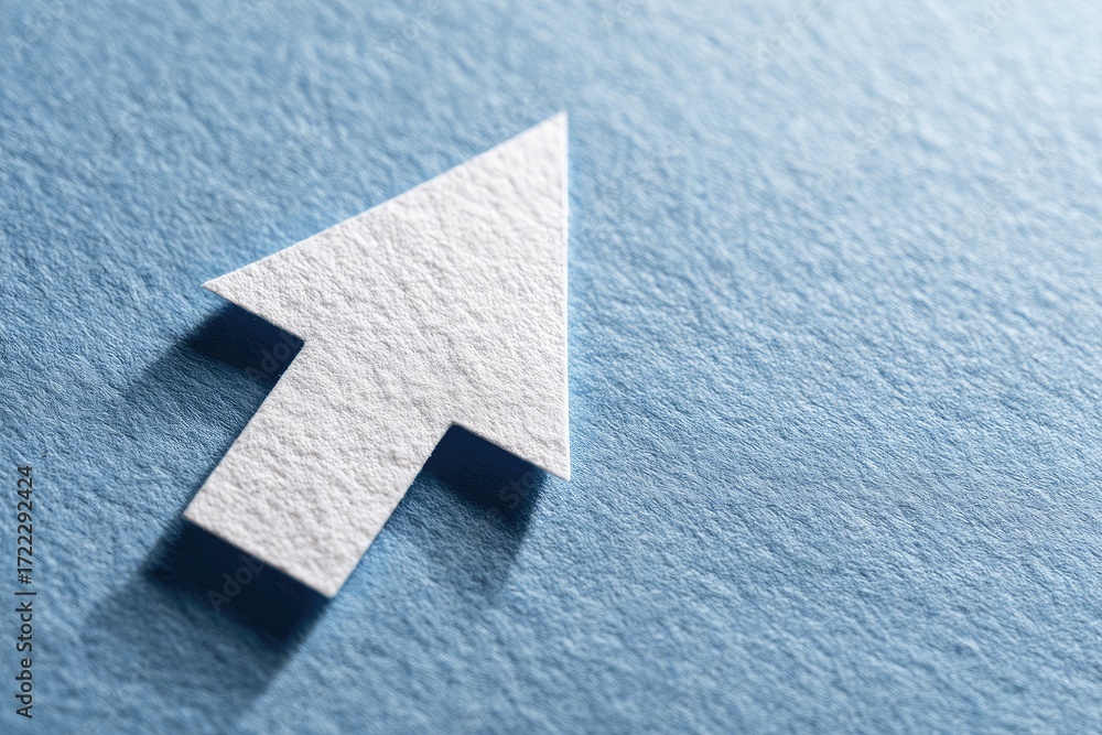 Fototapeta premium A close-up of a white paper arrow pointer, against a light-blue textured surface