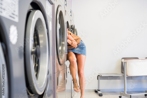 Woman searching inside industrial washing machine