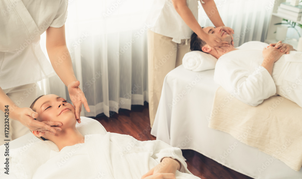 Obraz premium Caucasian couple enjoying relaxing anti-stress head massage and pampering facial beauty skin recreation leisure in dayspa modern light ambient at luxury resort or hotel spa salon. Quiescent