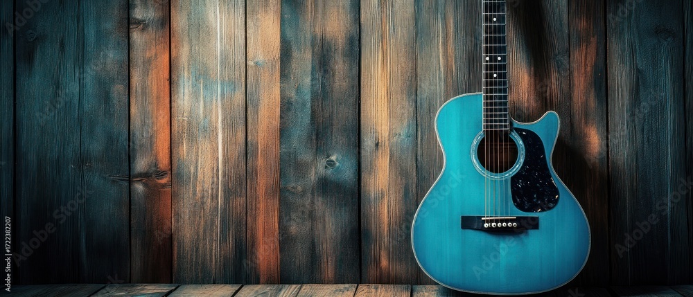 Naklejka premium Teal acoustic guitar on rustic wooden background