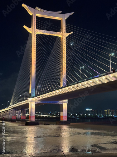 Ponte suspensa iluminada à noite sobre o rio em Guangzhou, China