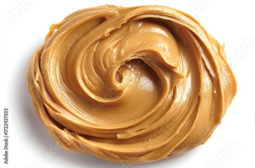 Swirl of smooth peanut butter spread on a white surface, showing creamy texture and natural light creating shadows around its edges