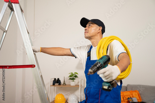 Diligent Technician in Action: A skilled technician ascends a ladder while carrying tools, ready to perform maintenance.