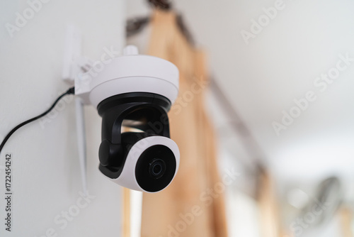 Indoor security camera mounted on a wall providing monitoring and surveillance for home or office safety and security in contemporary interior design