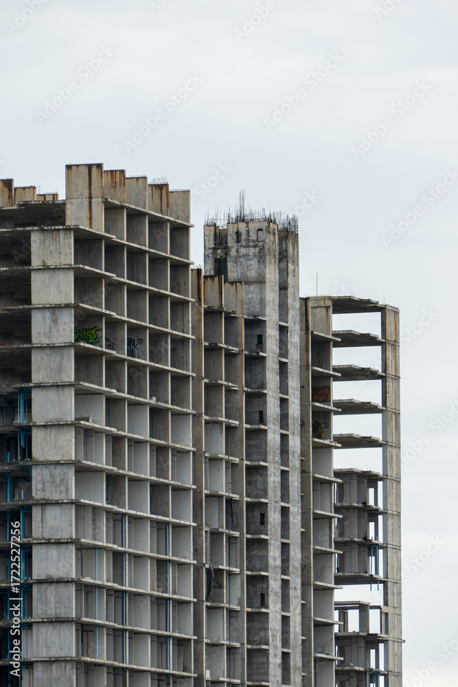 Fototapeta premium Urban decay abandoned concrete towers in a grey sky architectural dystopian environment wide angle view