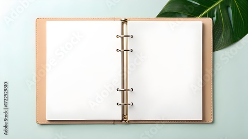 Wallpaper Mural Open ring binder notebook mockup with blank pages. A green tropical leaf on a light blue surface creates a fresh, simple design template Torontodigital.ca