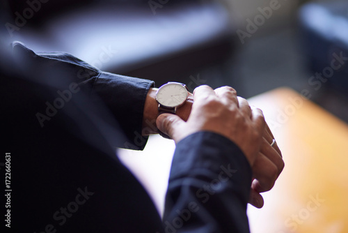 腕時計で時間を確認する日本人シニア男性の手元