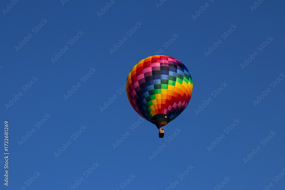 Obraz premium Colorful Hot Air Balloon Against a Clear Blue Sky