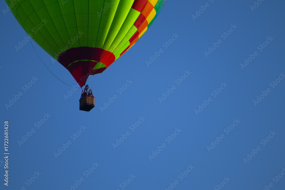 Obraz premium Colorful Hot Air Balloon Against a Clear Blue Sky