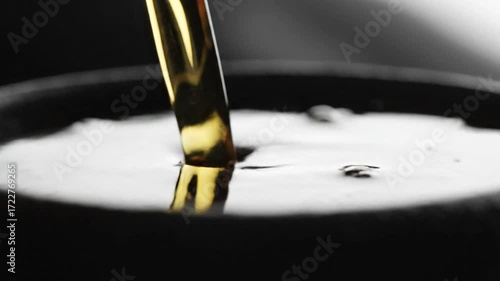 Wallpaper Mural Close-up of golden liquid pouring into a bowl with a dark background and dramatic lighting. Torontodigital.ca