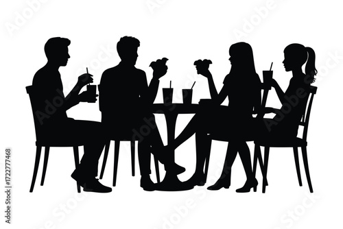 Silhouettes of friends enjoying a meal together at a table