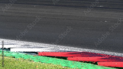 Racing car speed on curb at turn on asphalt track, original sound engine