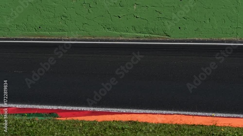 Racing car speed on curb at turn on asphalt track, original sound engine
