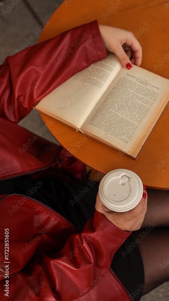 Fototapeta premium Woman reading a book and holding a coffee cup