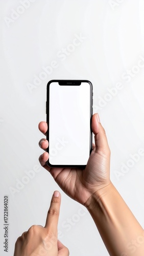 A hand holds a modern smartphone with a blank white screen, poised to touch it, against a clean, bright white background