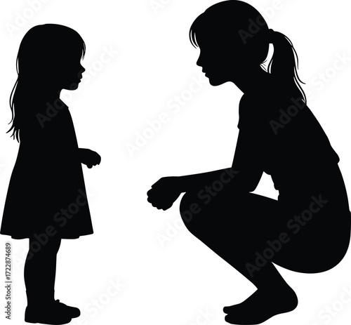 Silhouette of a woman squatting down and talking to a young girl, symbolizing nurturing, communication, and bonding