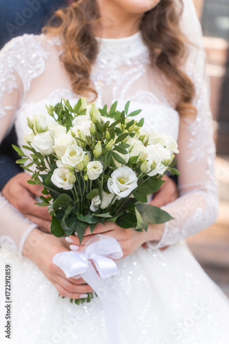 Close-up wedding couple bride and groom walk hand in hand through a pine forest, sunlight filtering through the trees