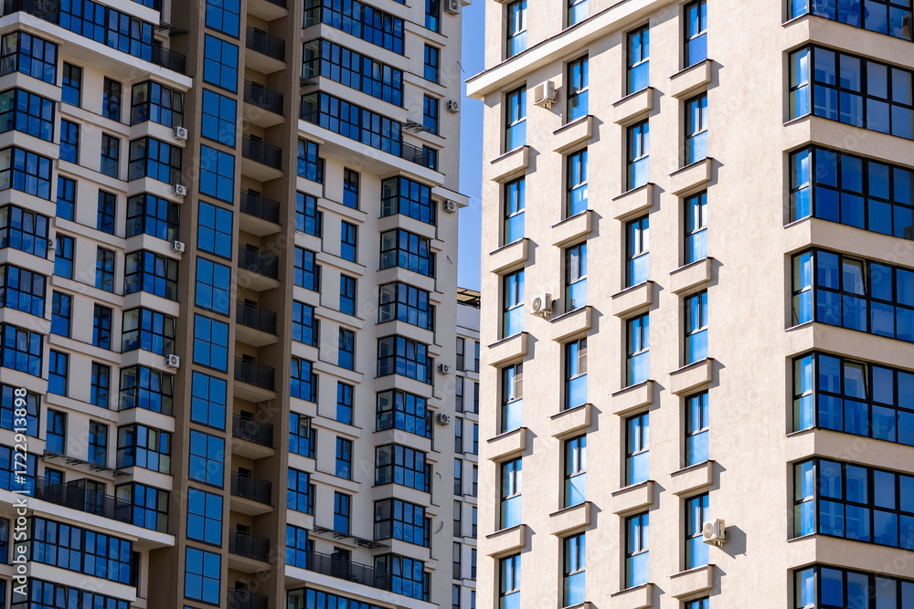 Fototapeta premium Modern luxury residential flat. Modern apartment building on a sunny day. Apartment building with a blue sky. Facade of a modern apartment building.