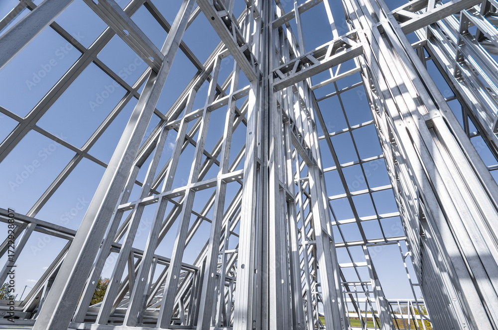 Obraz premium Building in construction, Metallic structure against a clear sky. New residential construction home metal framing.