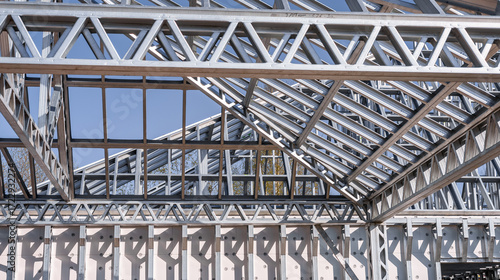 Structure of steel roof frame for building construction on sky background.