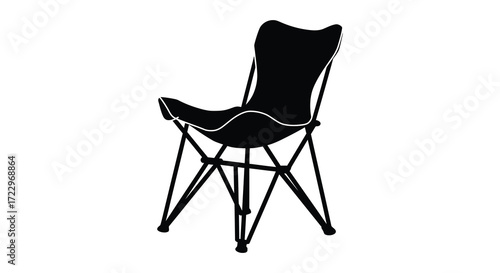 A stylish black butterfly chair shown in a dramatic stark silhouette