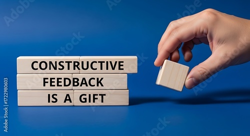 Constructive feedback message communicated through wooden blocks on blue background