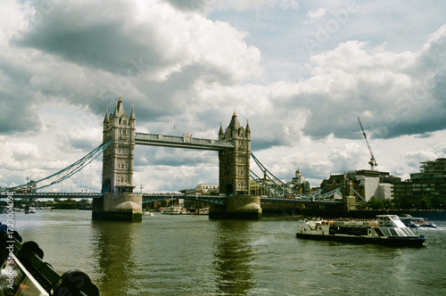 Tower Bridge spanning the River Thames in London with dramatic cloudy sky and boats passing below. Film Photography. Leica M2 x Superia 200, London 20 May 24