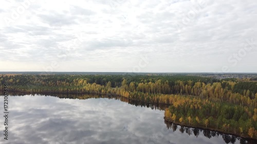 a flight over autumn trees and a large Siberian lake
