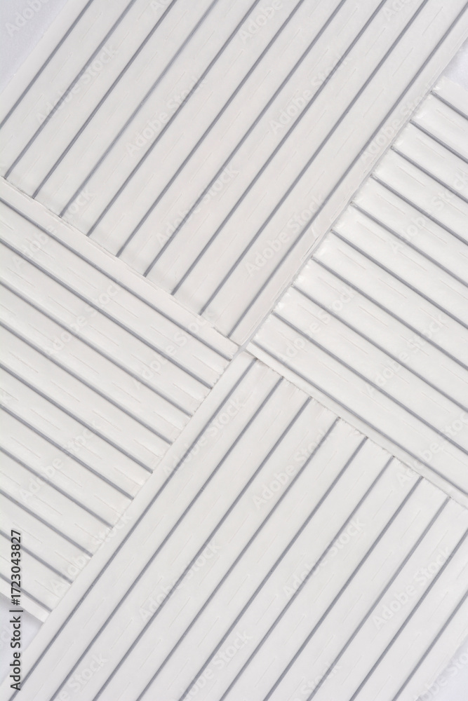 Obraz premium A close-up photograph of four rectangular pieces of white plastic twist ties with wire cores, arranged to form a crisscross pattern