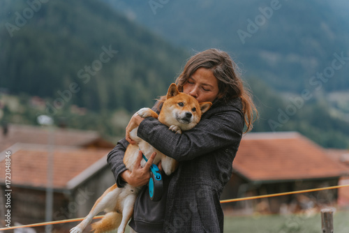Woman showing affection to shiba inu dog outdoors