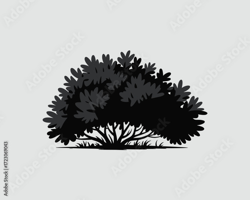 Silhouette of a dense green bush with visible branches and grass