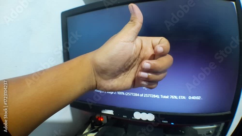 natural video without stabilization of a computer technician showing thumbs up in front of a monitor showing the process of repairing a PC storage drive