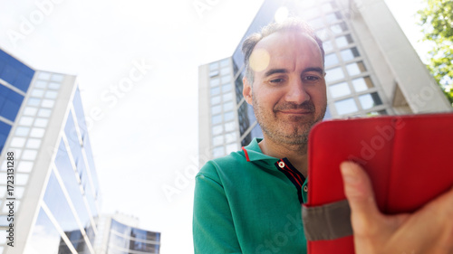 Middle-aged man with a tablet from below outdoors