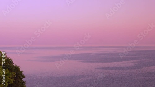 Amazing Window View of the Sea Lilac Pink Orange Pure Cloudless Sunrise Sky in Sun Rays Tree Sun Horizon. Calm Ocean Clear Colorful Sky in Sunlight. Tourism, Vacation, Planet, Sunset.