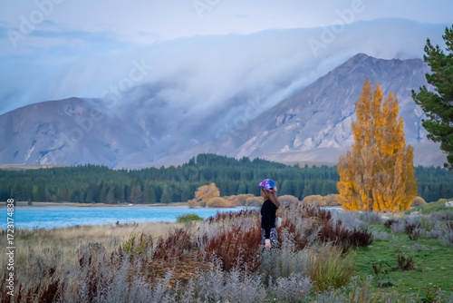 people enjoy beautiful landscape view of colorful leaves , turquoise lake and  snow cap moutain background at Lake Tekapo South Island New Zealand in the autumn